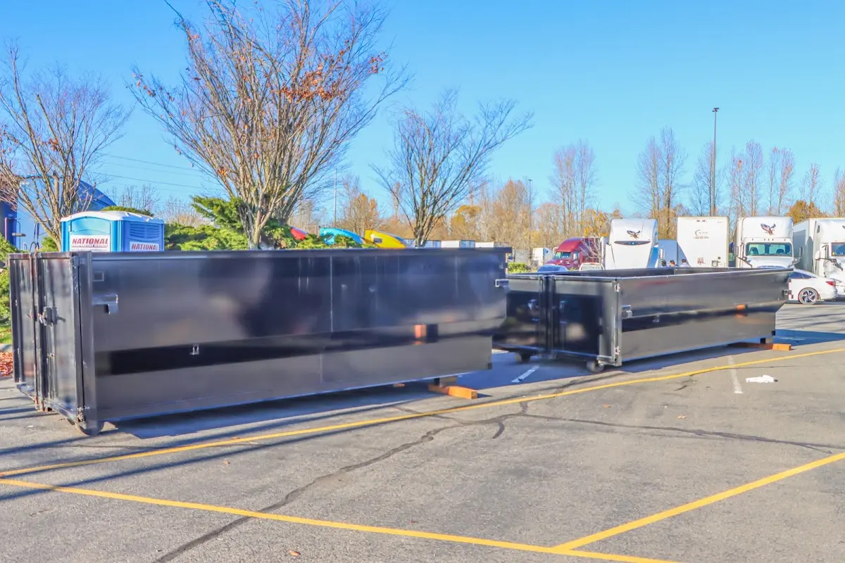 Professional dumpster rental service with roll-off container on residential driveway in Cape St. Claire